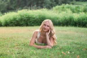 A girl laying in the grass during senior portraits at Middle Creek Wildlife Management Area in Stevens PA