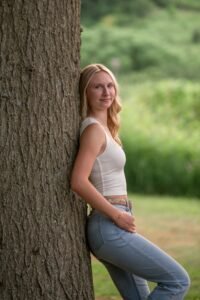Senior portrait in Ephrata PA of blonde woman leaning against a tree.